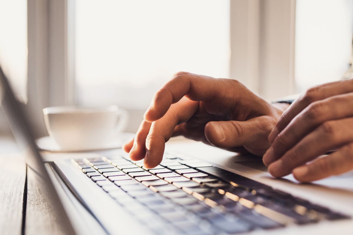 A man's hand using a laptop.