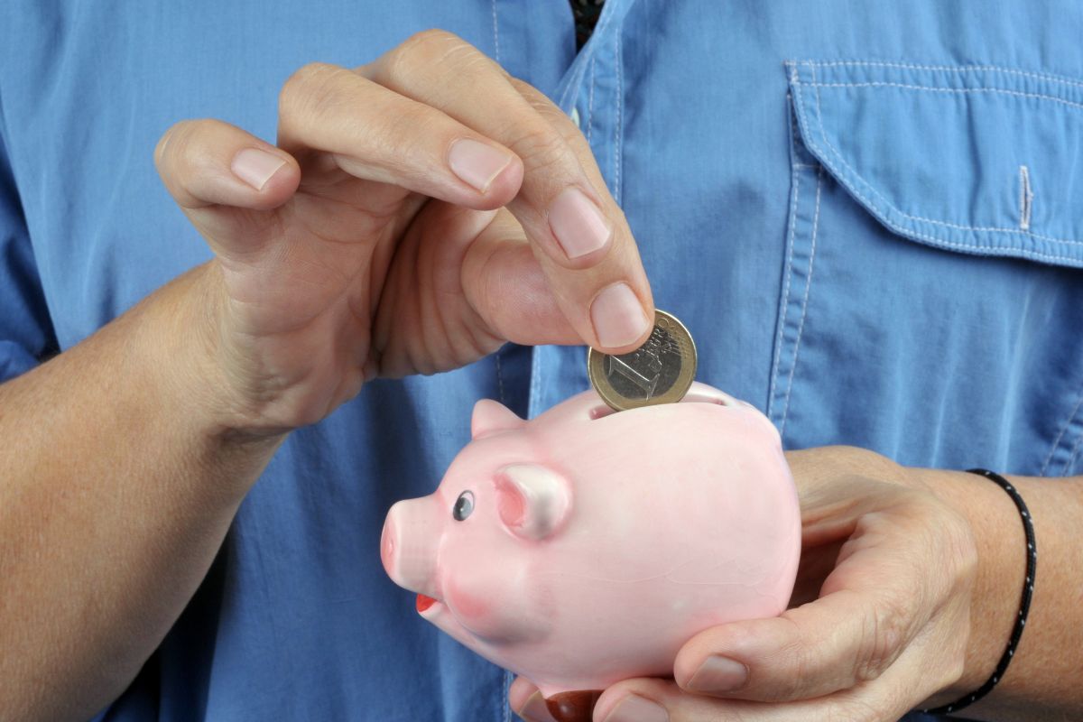 Photo shows a man saving small money.