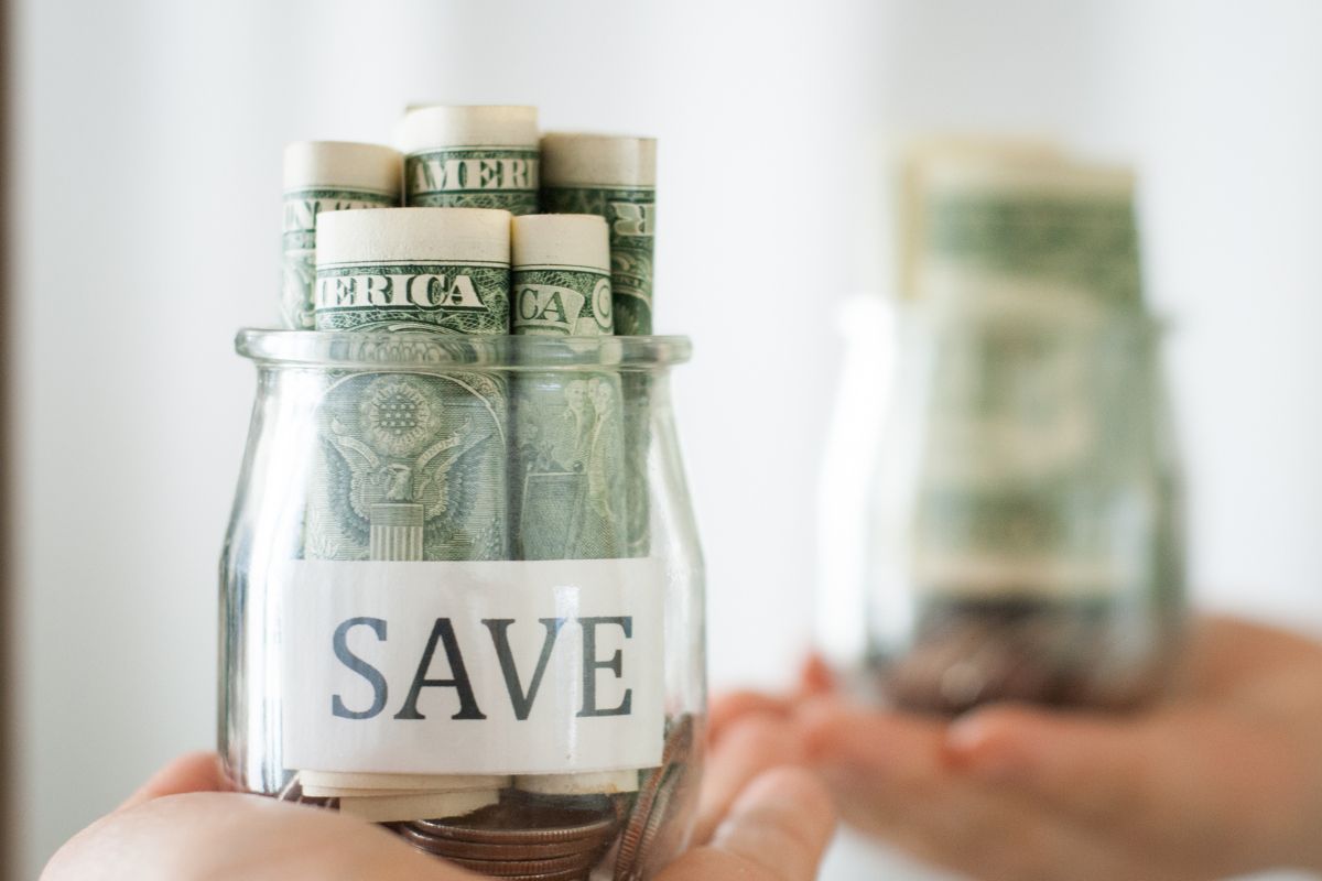 The photo shows a woman's hand holding savings.