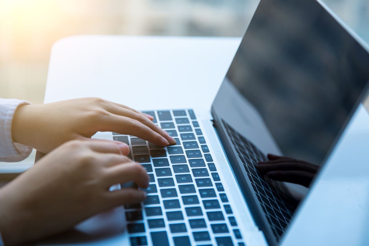 A woman's hand using a laptop.