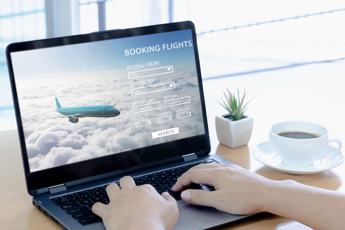 The image shows a man's hand booking a flight.