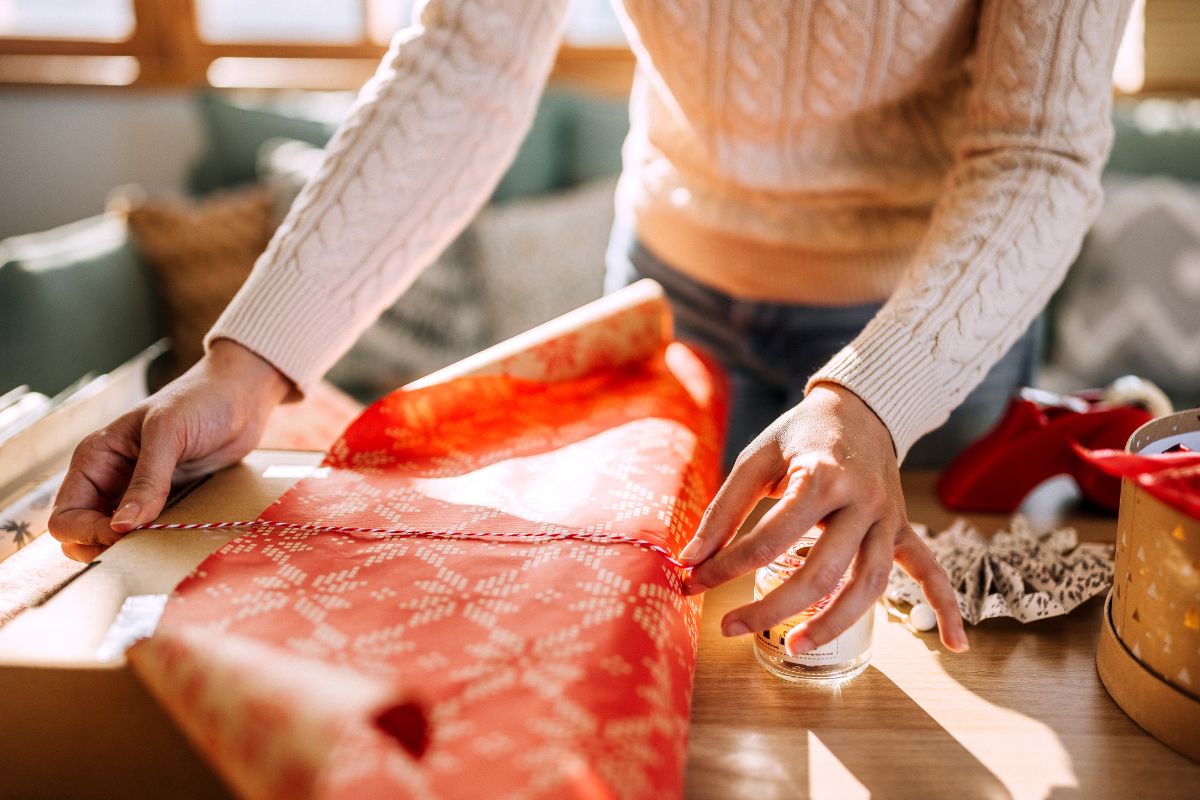 A woman's hand wrapping a gift.