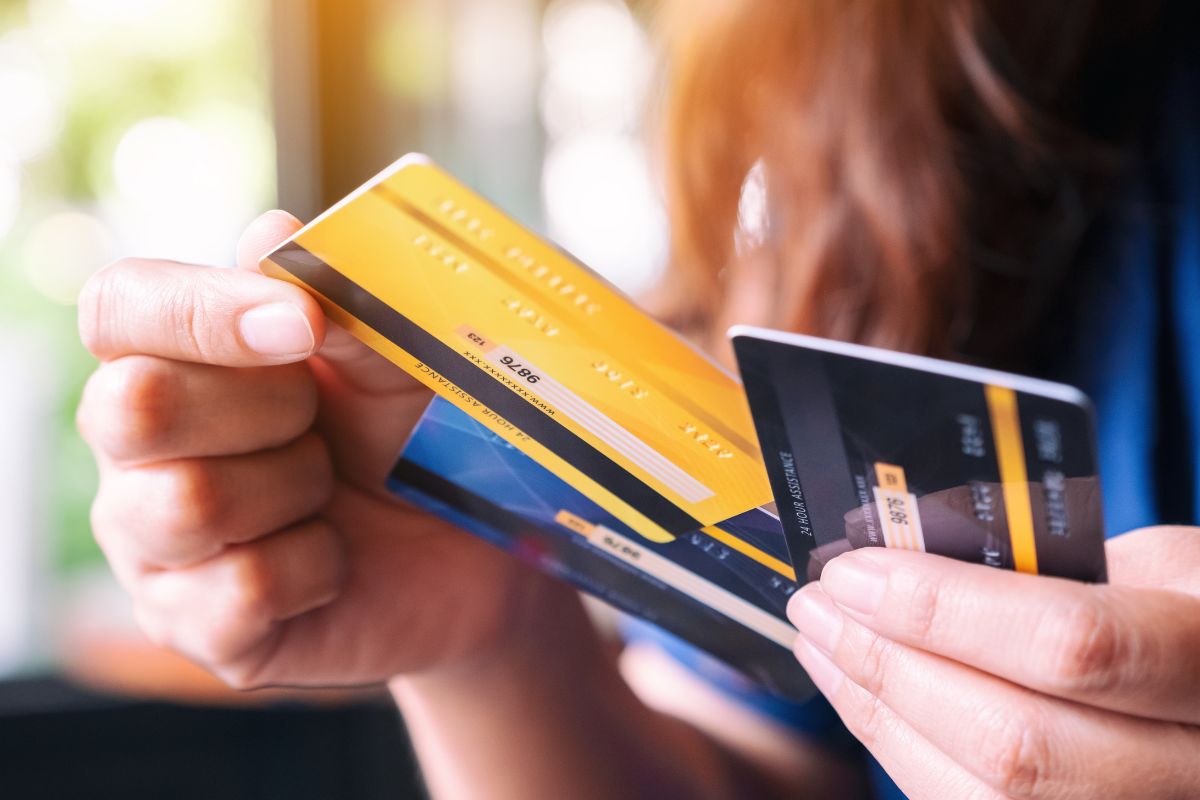 A woman's hand holding credit cards.