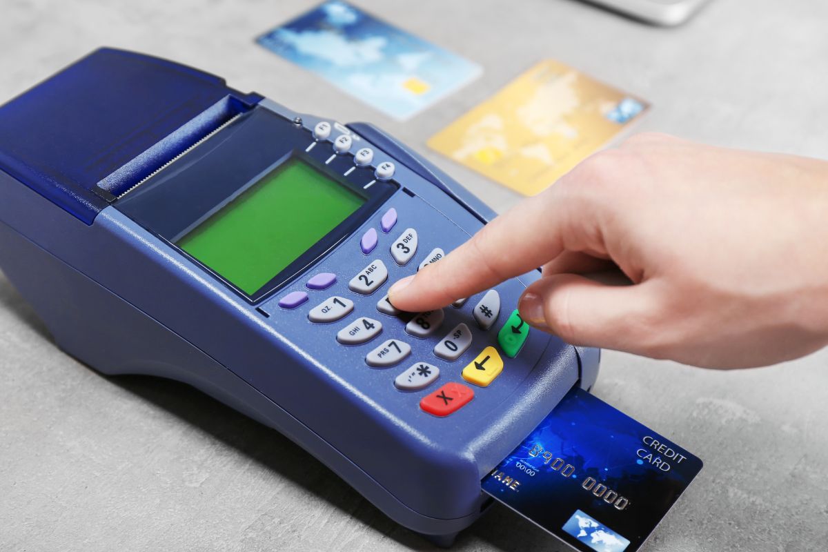 Aman's hand paying with a credit card.