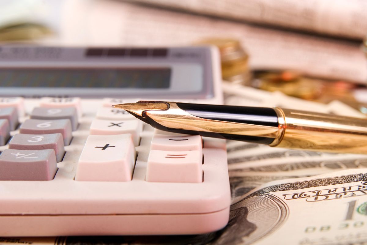 Photo of money, a pen, and a calculator,