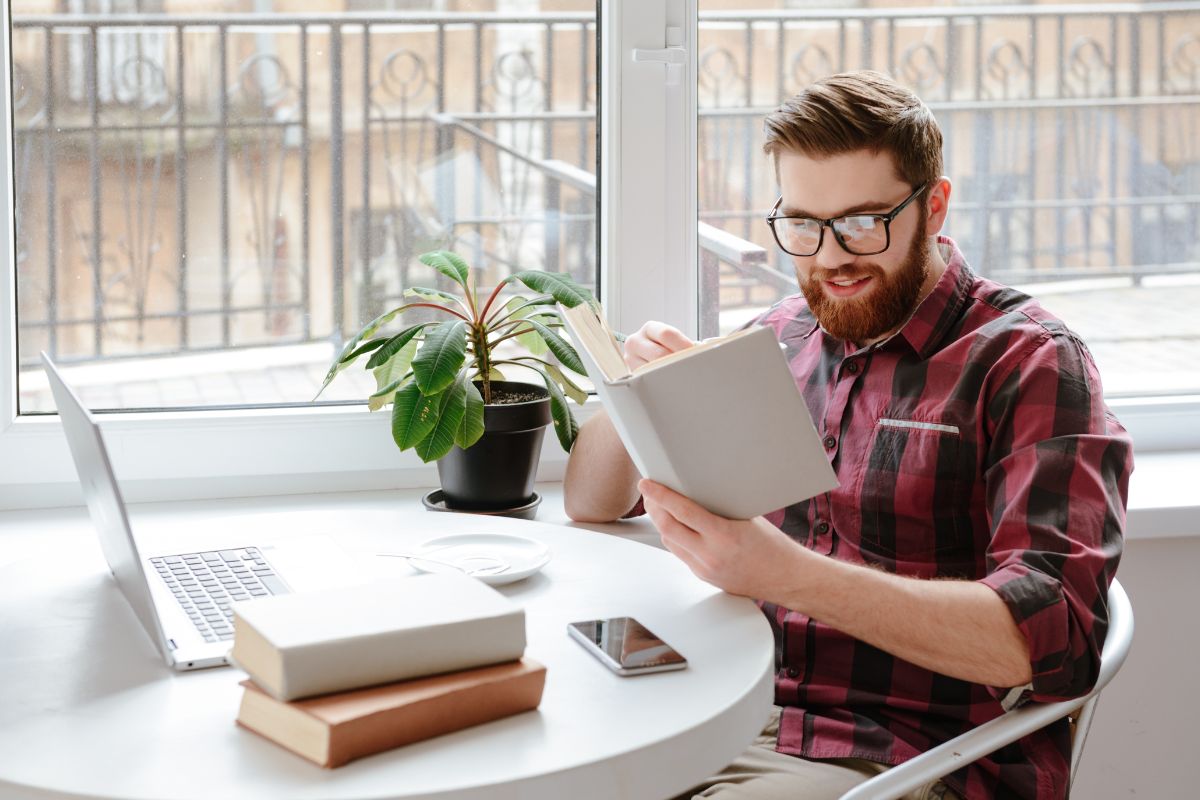 Photo of a man reading a finance book.
