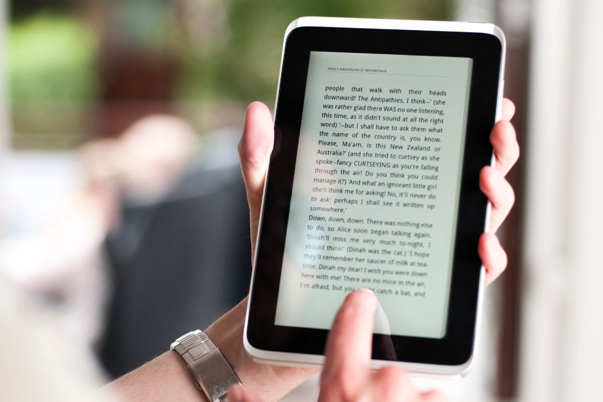 Image shows a woman's hand reading an E-book.