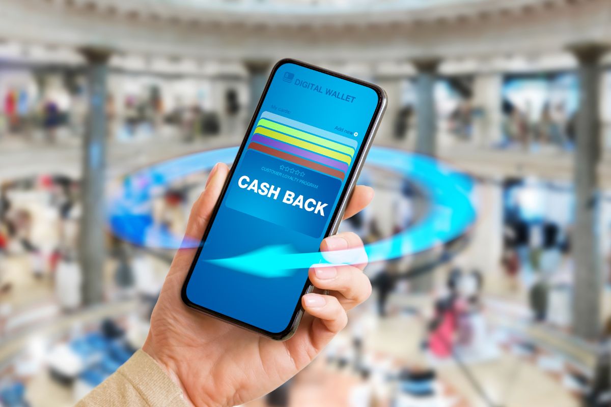 The hand of a woman using a phone with cashback.