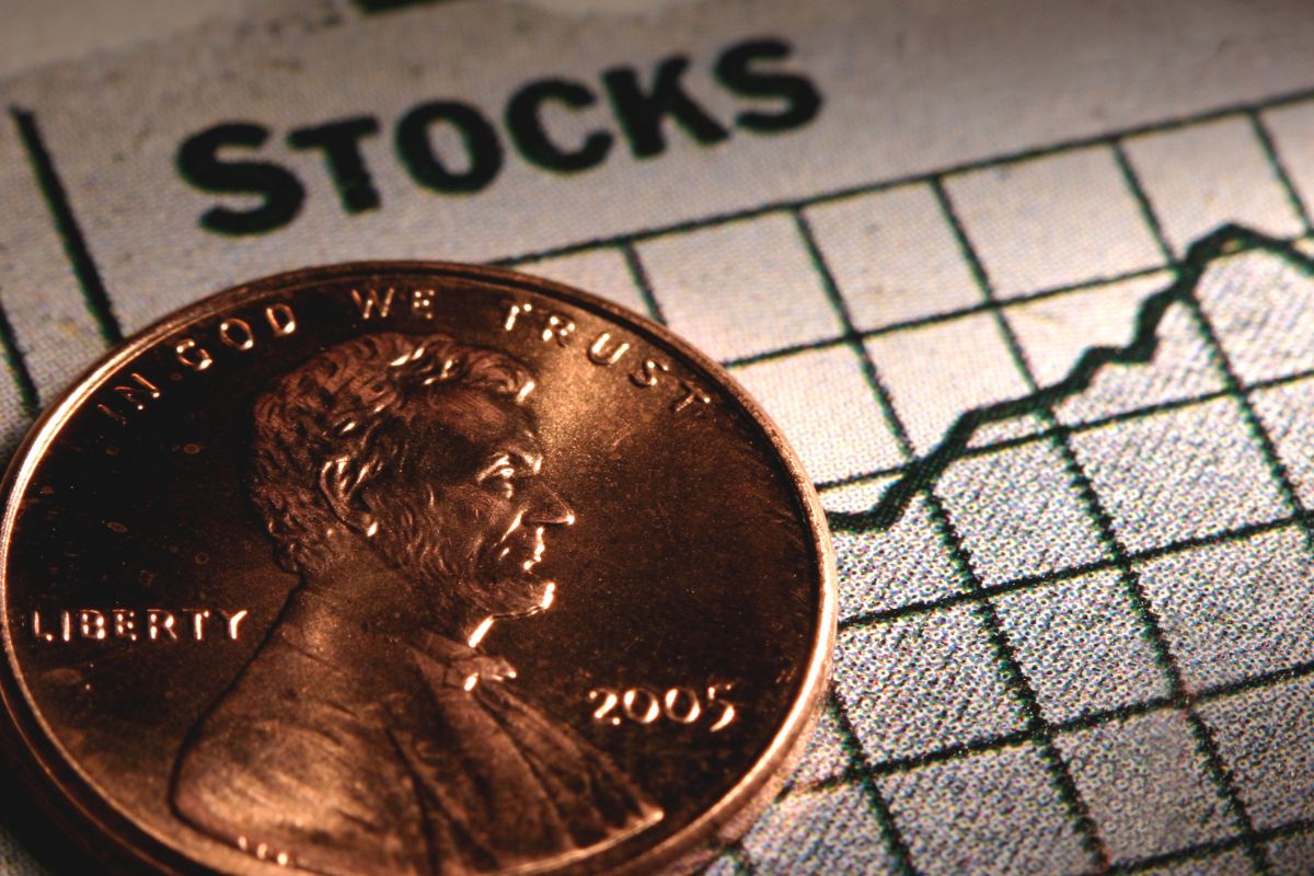 Photo of a coin and stocks wording.