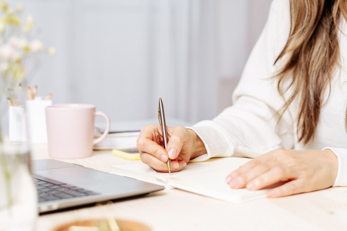 Photo d'une femme écrivant dans un carnet.