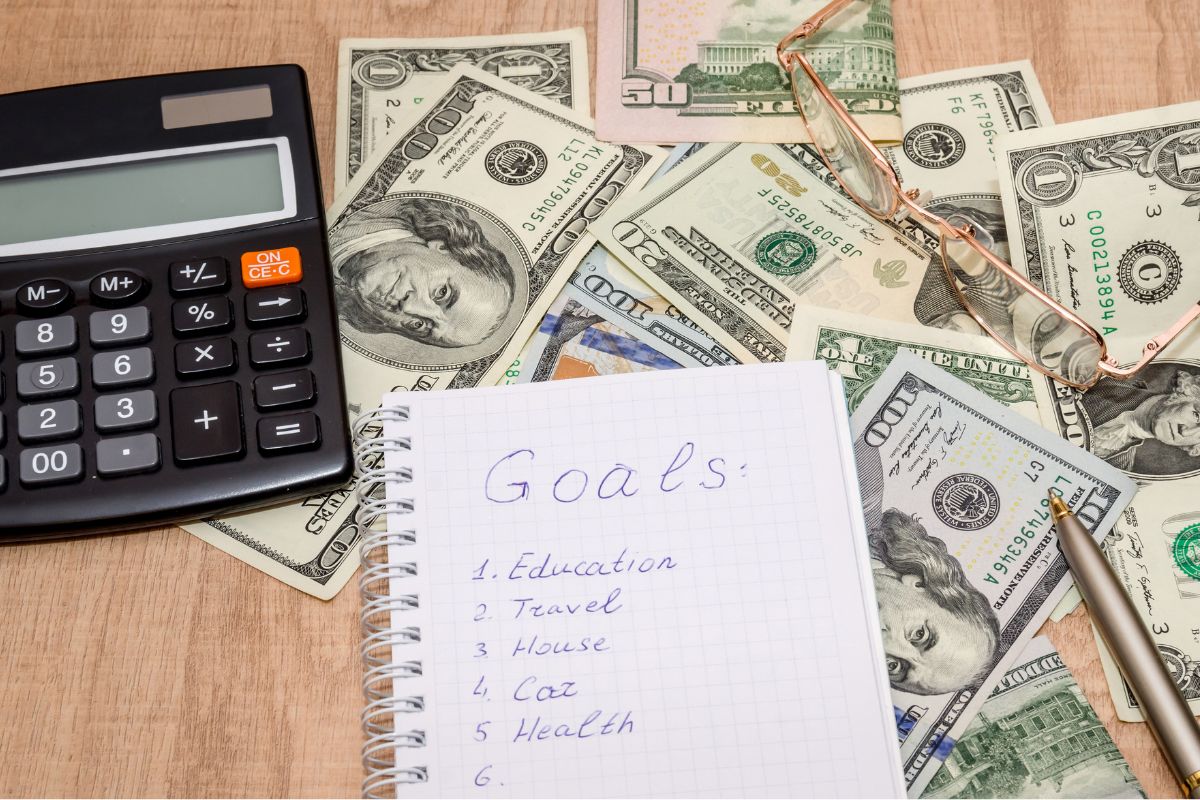 Picture of money and a notebook with goals list.