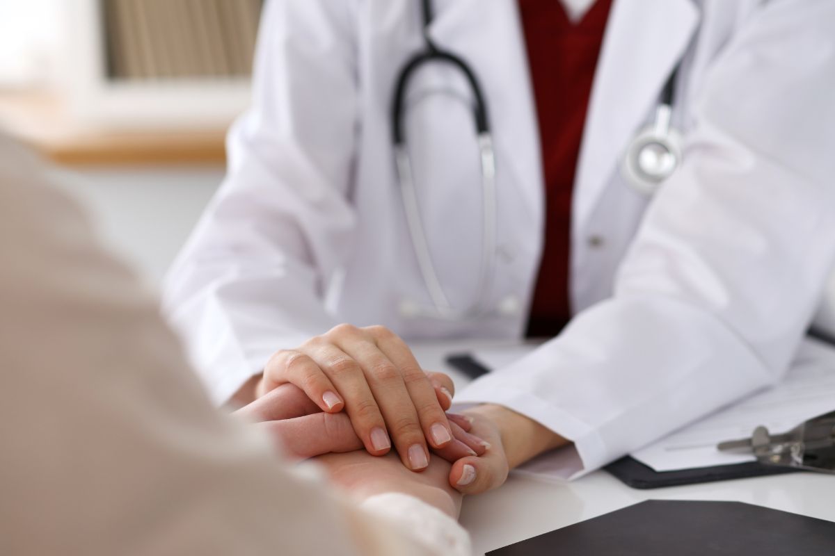 The photo shows a doctor comforting a patient.