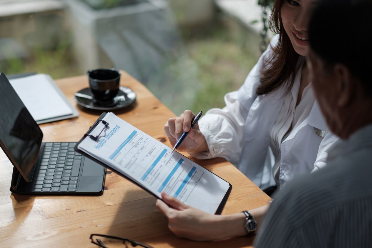 The photo shows an insurance broker with her client.