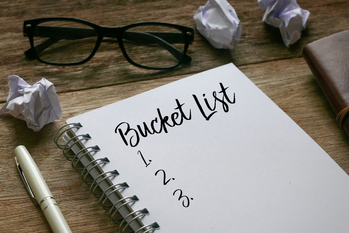 The picture shows a notebook with bucket list wording.