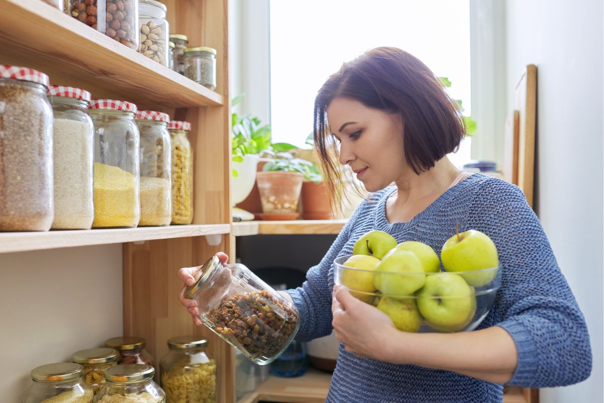 A woman checking for ingredients in the pantry.