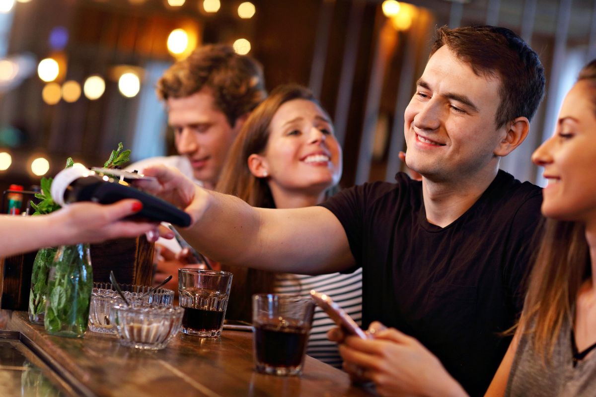 Image of a man tipping in a bar.