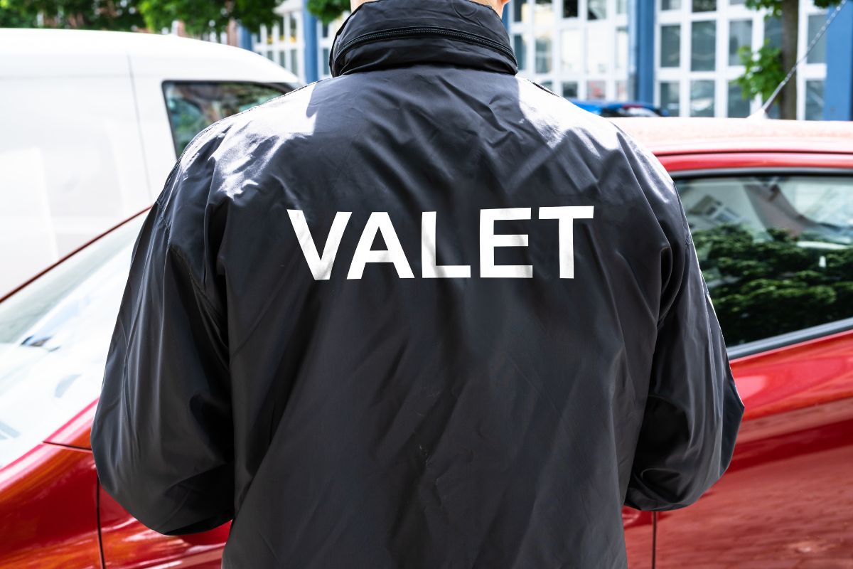 The image shows a man working as a valet.