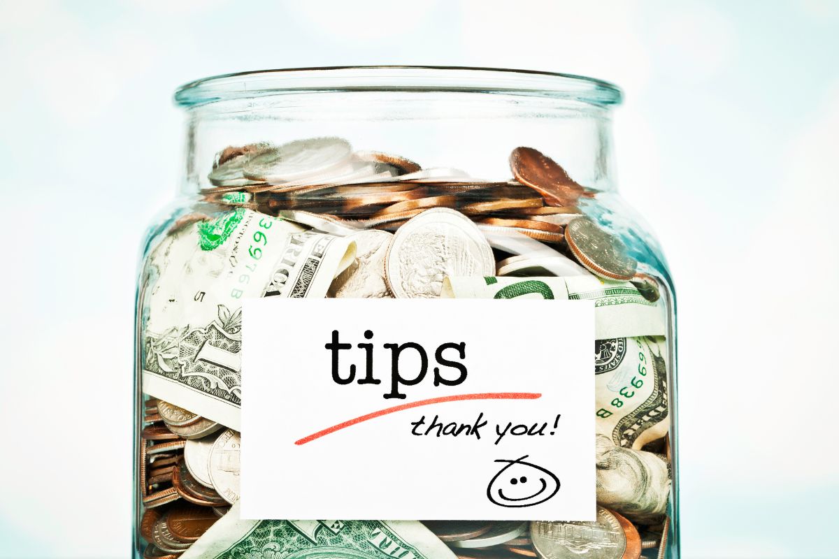 The picture shows a jar with money and tips wording.