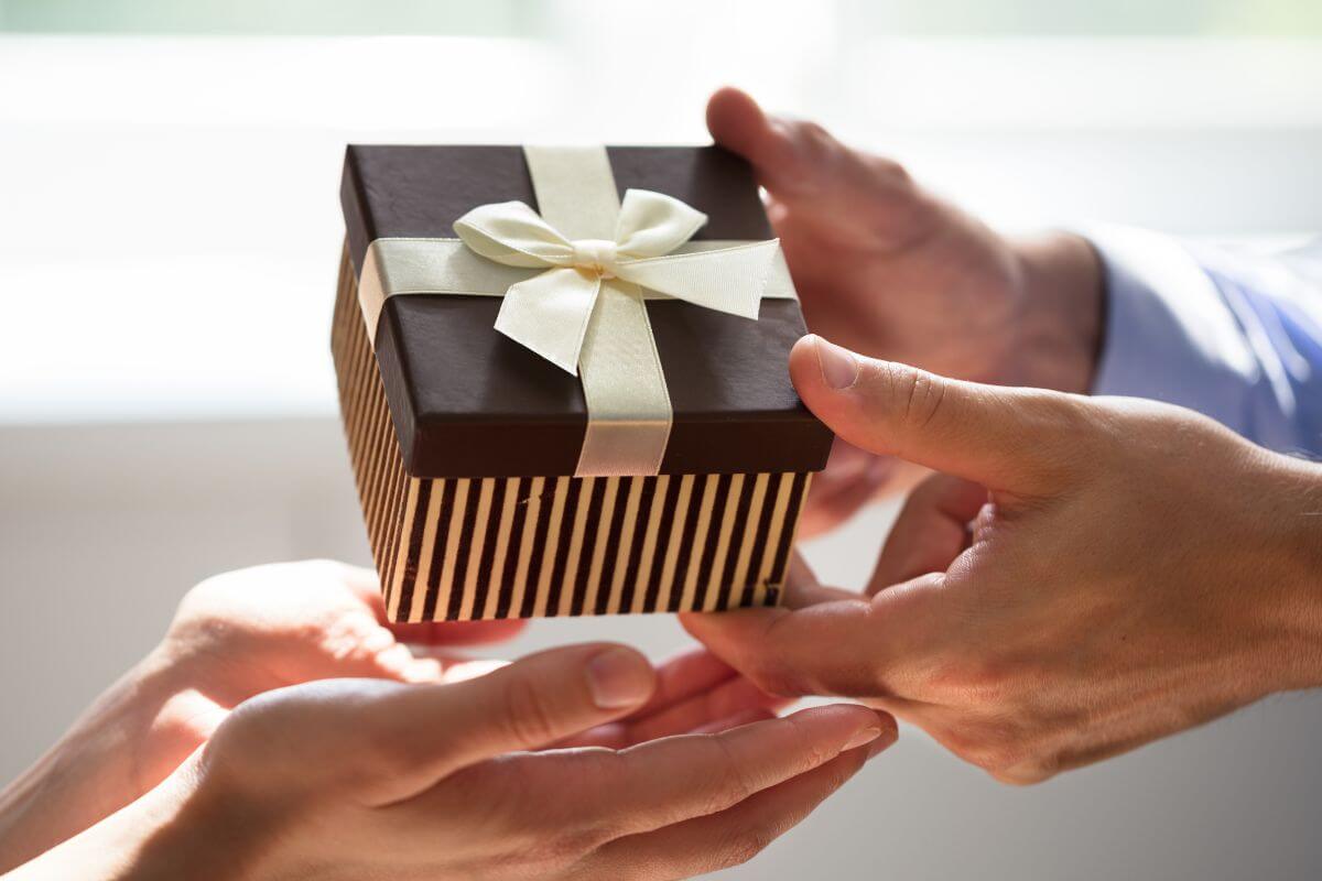 The image tells about a man's hand giving a gift to a girl's hand which means to give small but thoughtful gifts to say specially thank you.