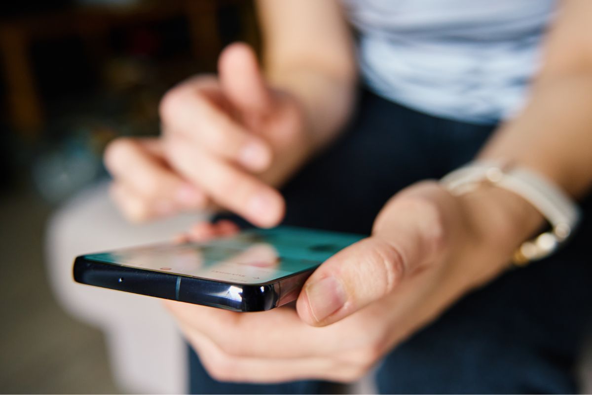 Photo of a woman's hand using a phone.