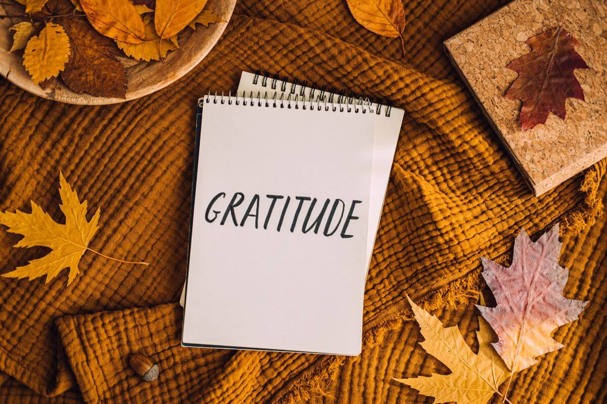 The picture shows leaves and notebooks with notes referring to crafting a gratitude tree, a creative way to express thanks visually.