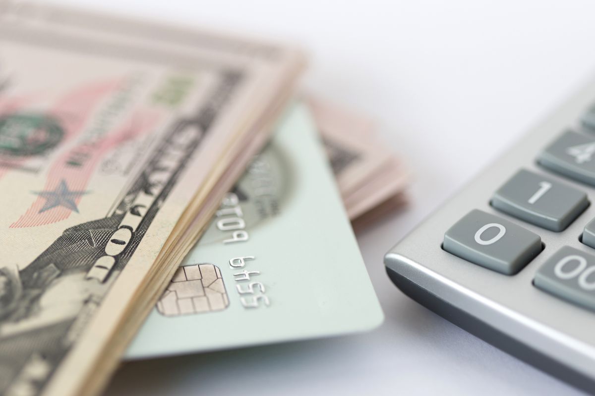 Photo of money,  a credit card, and a calculator.