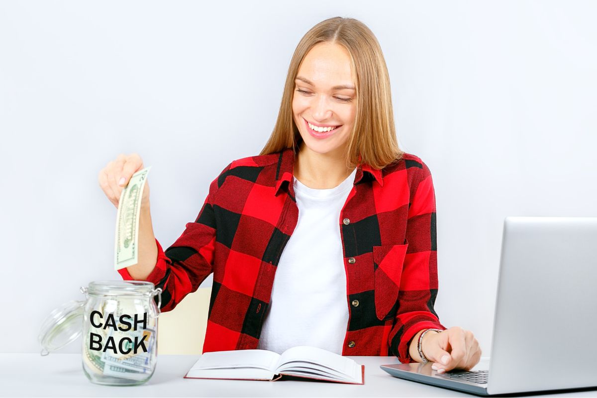 A woman saving putting money in a cashback jar.