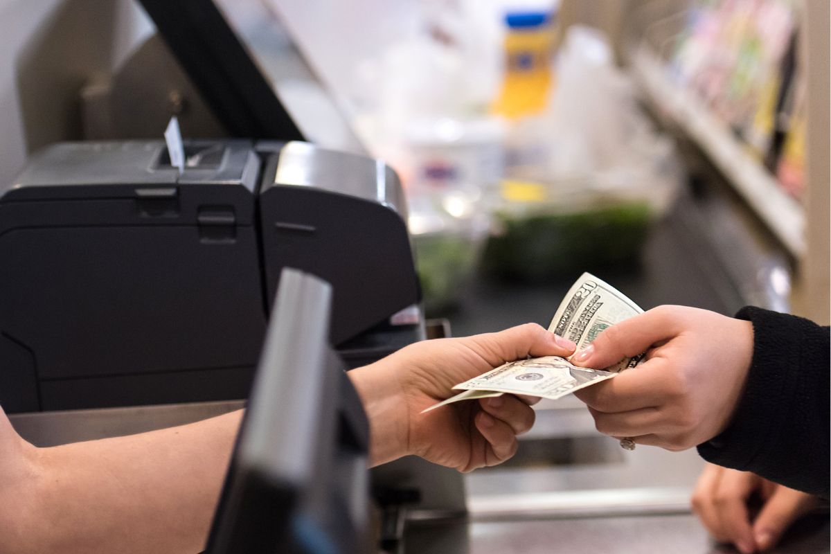 A woman's hand paying in cash.