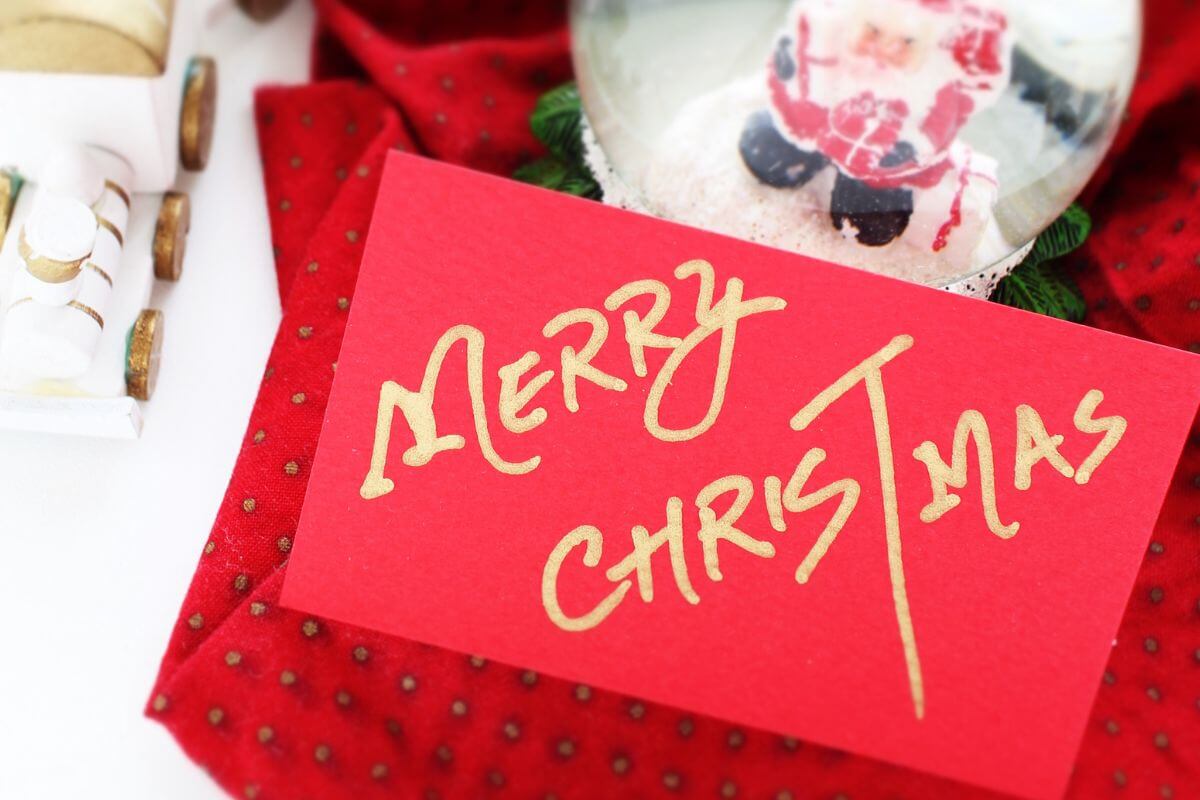 The picture of a Christmas ball with Santa Claus, a train, red fabric, and a piece of paper with notes indicating how to make a handwritten card is a free yet meaningful way to show you care.