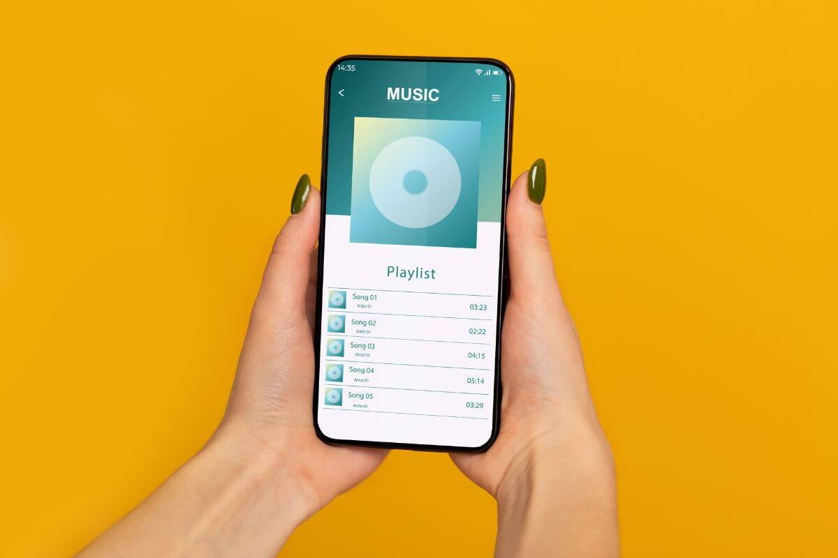The image of a girl's hand holding a phone with a screen display which refers to creating a personalized playlist that reminds your friends or family member is a simple yet thoughtful gift.