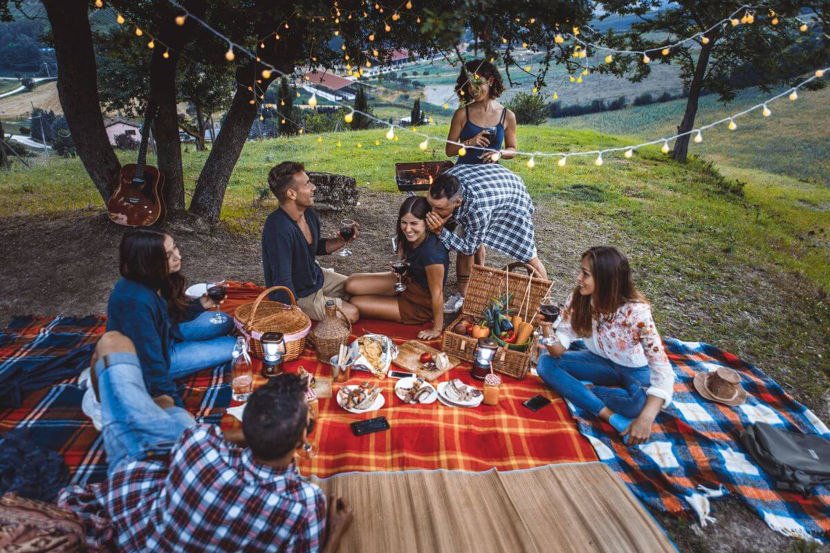 The image tells about a group of people enjoying together with their food indicating to plan a picnic and a low-cost way to create special memories together.