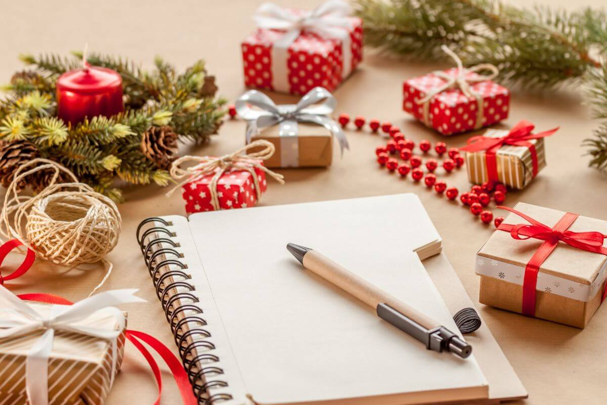The image tells about Christmas decorations, mini gifts, and a pen and notebook which means making a gift list to focus on meaningful gifts for close family and friends and also to avoid buying unnecessary items.