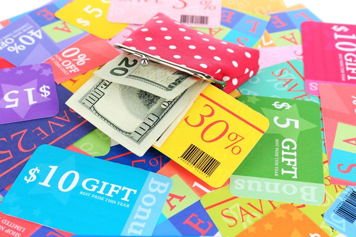 The photo of a wallet with dollar bills and coupons to use for holiday shopping helps cut costs and makes your money go further.