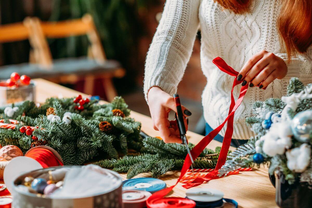 The image of a Christmas tree, ribbons, and a girl cutting a ribbon indicates limiting decorations and reusing items from previous years to enjoy the season without the added cost of new holiday decoration.