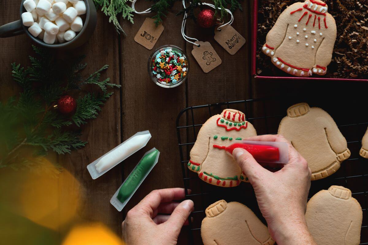 The picture of the man's hand doing the holiday traditions by decorating cookies instead of expensive gifts to keep costs down and lets everyone enjoy the season debt-free.