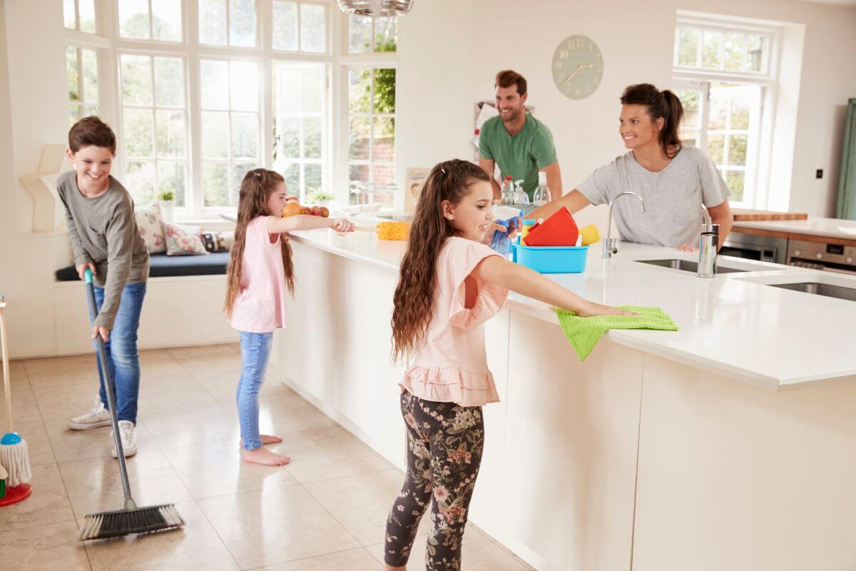 The picture tells about a group of family doing house chores together which means delegating household tasks to balance responsibilities and ensure no one feels overwhelmed at home.
