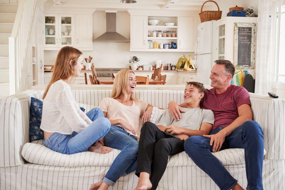The picture tells about a group of family laughing together which means planning regular check-ins with family avoids misunderstanding and keeps everyone happy.