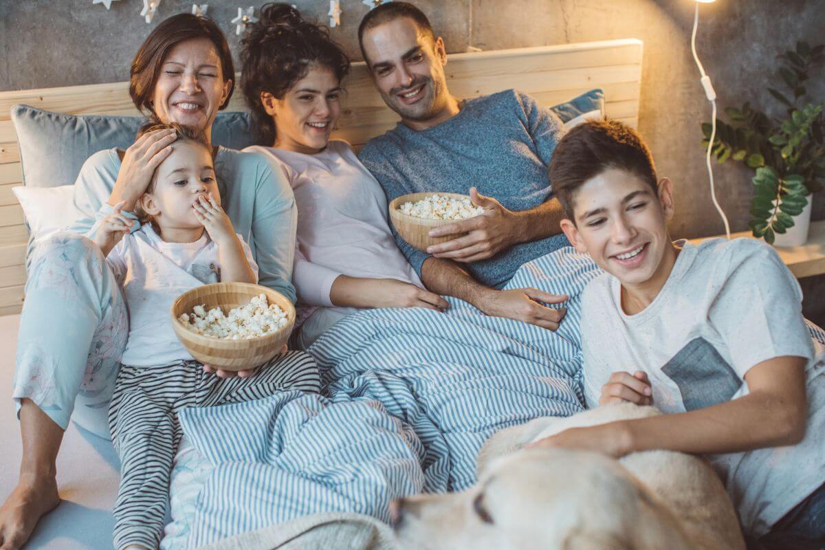 The photo of a group of families with their popcorn means hosting a family movie marathon as one of the fun activities for Christmas day.