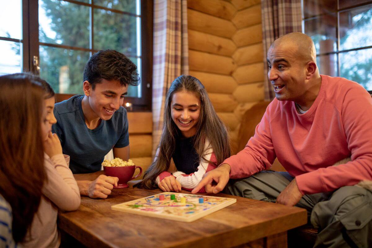 The picture tells about a father with his children playing board games together which refers to gathering everyone to play it and pass the time together on Christmas day.