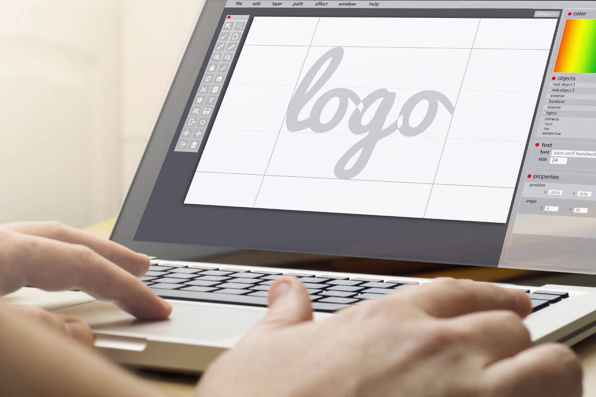 The photo of a teen's hand using a laptop with a screen display refers to learning graphic design offering freelance services and building a portfolio while earning good money.
