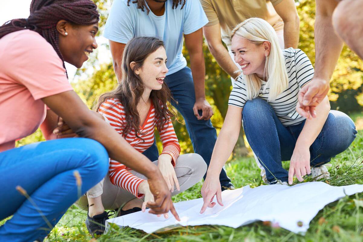 The image shows a group of people pointing to the white paper indicating to go for a holiday-themed scavenge hunt around the house or neighborhood with family or friends.