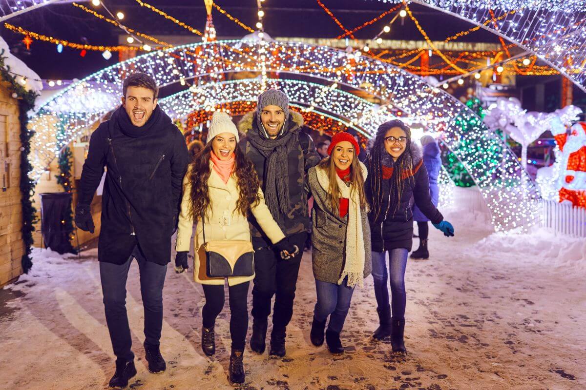 The photo tells about a group of people enjoying together which means taking a walk to see Christmas lights to enjoy the holiday decorations and spend time together.