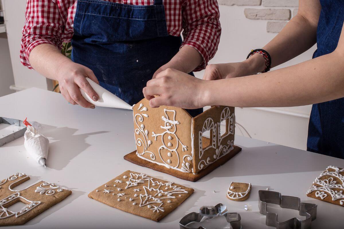 The picture of the two girls designing cookies means to build a gingerbread house competition to make it a fun and tasty holiday challenge.