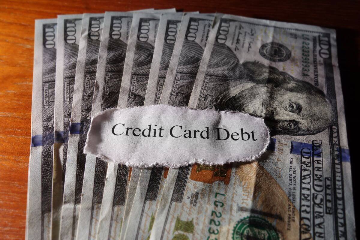The picture shows dollar bills and a piece of paper with notes referring to start paying off credit card debt to avoid high-interest charges, reduce stress, and save money.