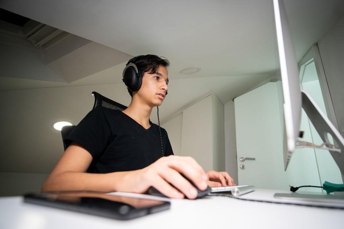 The image tells about a teen using a desktop computer which means to assist with tech support or set up for family or friends a useful way to make money while improving your skills.