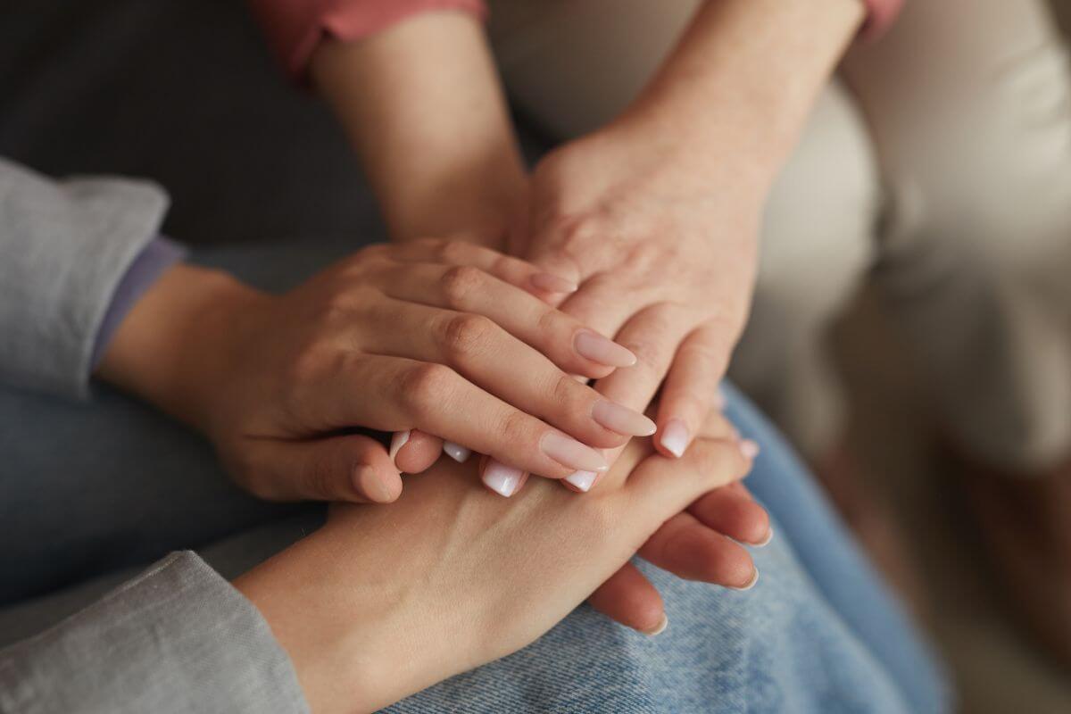 The image shows of women hands holding each others which means to build a support network with people who have similar financial goals can keep you motivated.
