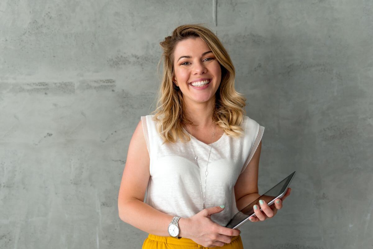 The image shows a girl with a tablet device which means to start your financial journey here with money bliss to create a stable financial future.