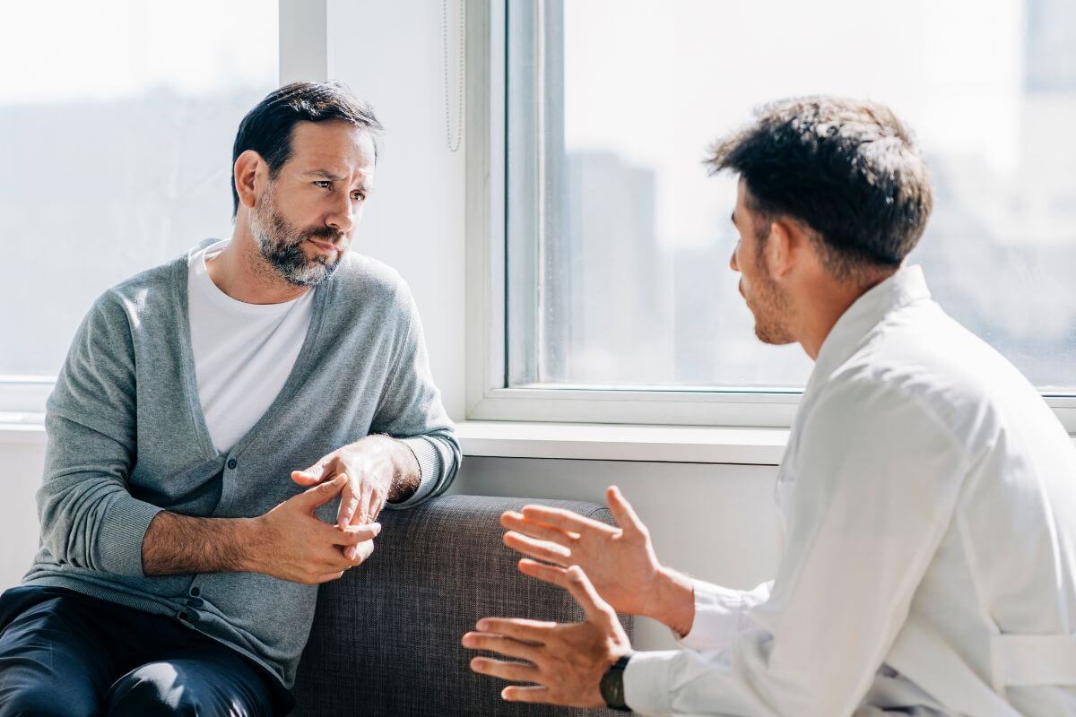 The image shows a man and a financial advisor talking to each other which means to seek financial counseling if needed that can provide guidance and strategies to tackle debt effectively.
