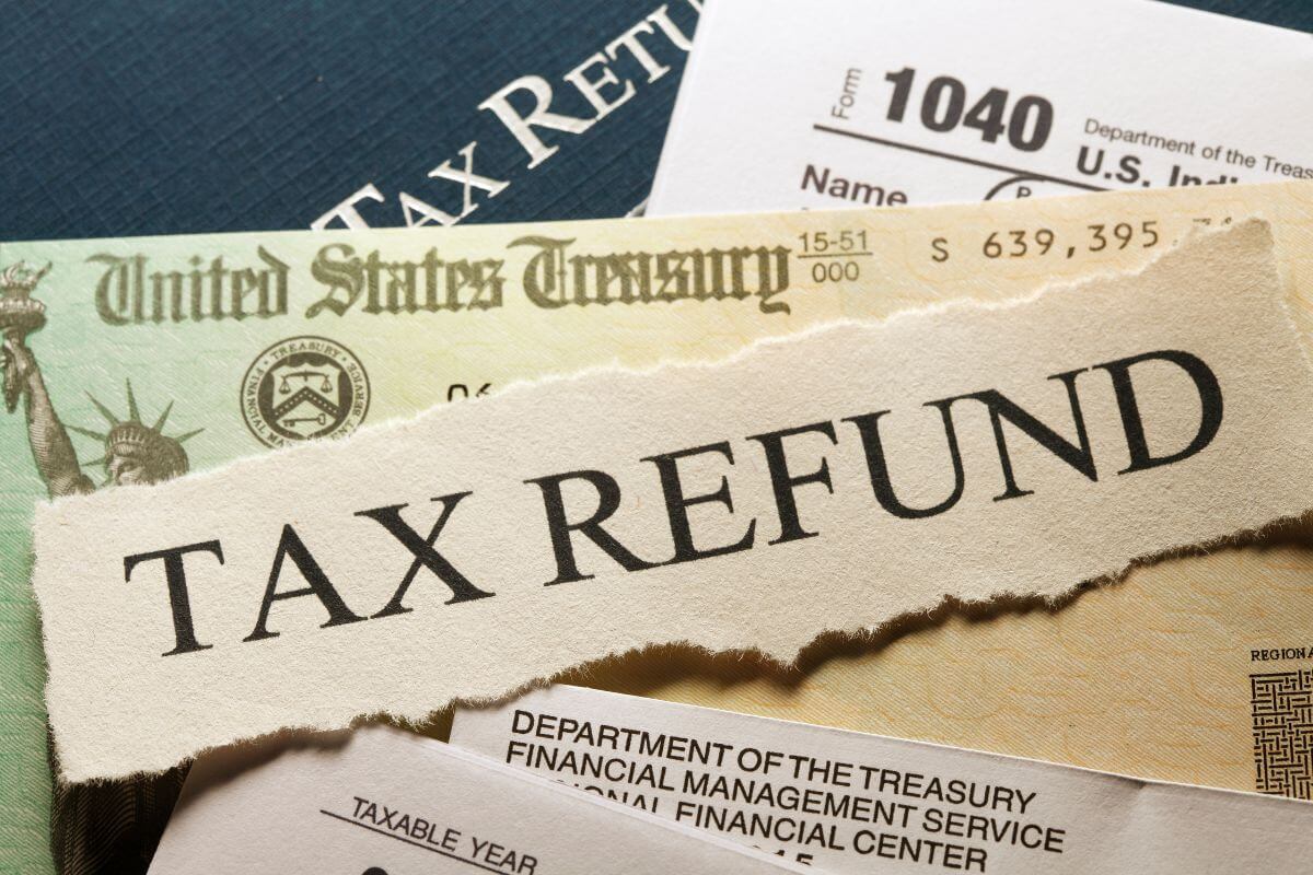 The image shows papers with notes indicating to use any tax refunds to pay down debt if you put them straight toward payments.