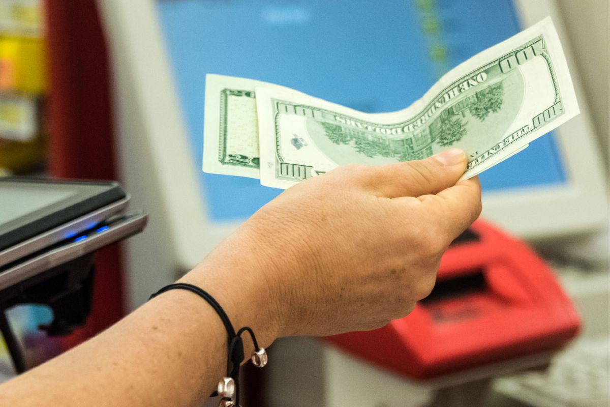 A woman's hand paying with cash.